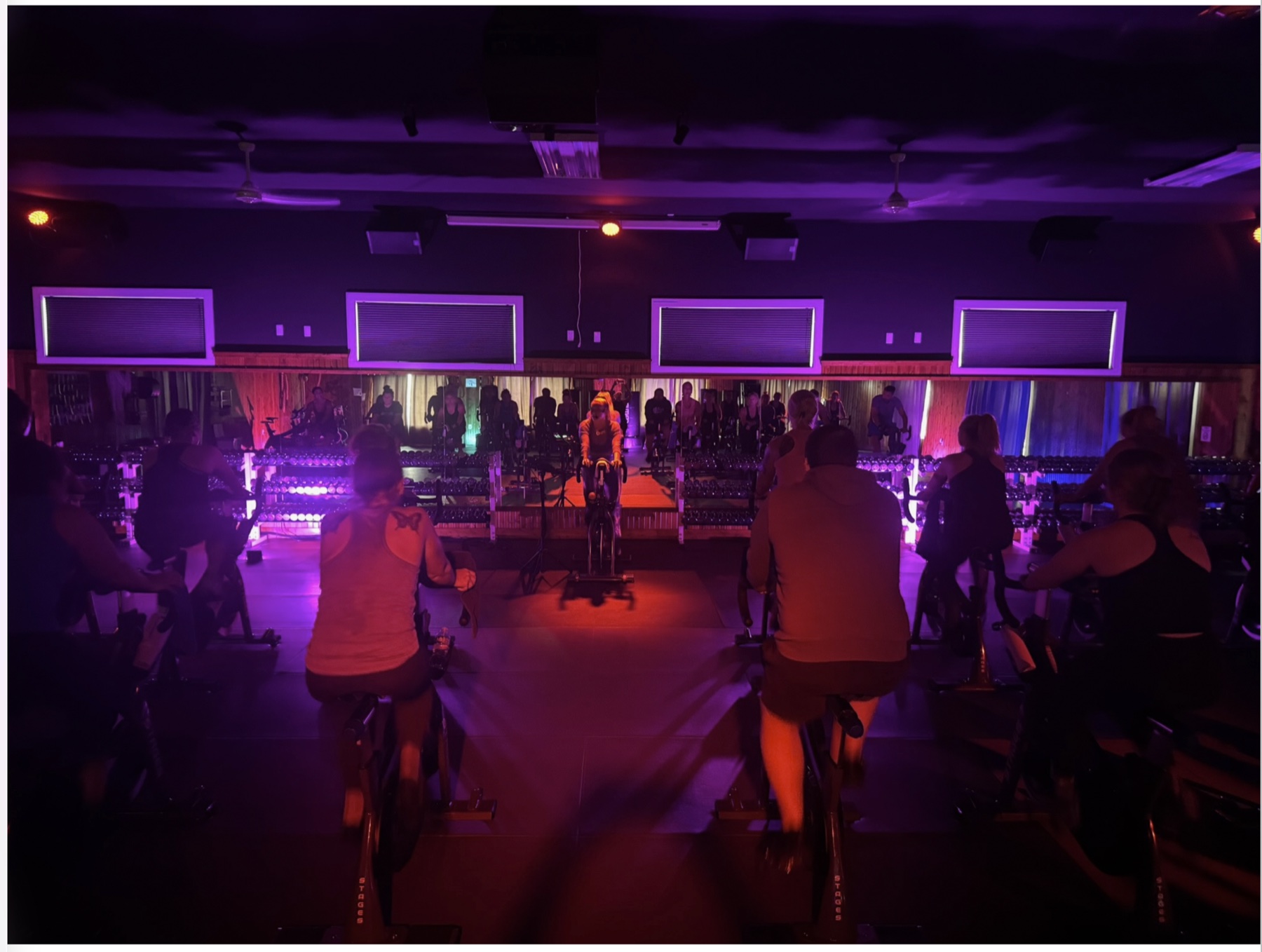A cycling class under colorful studio lights